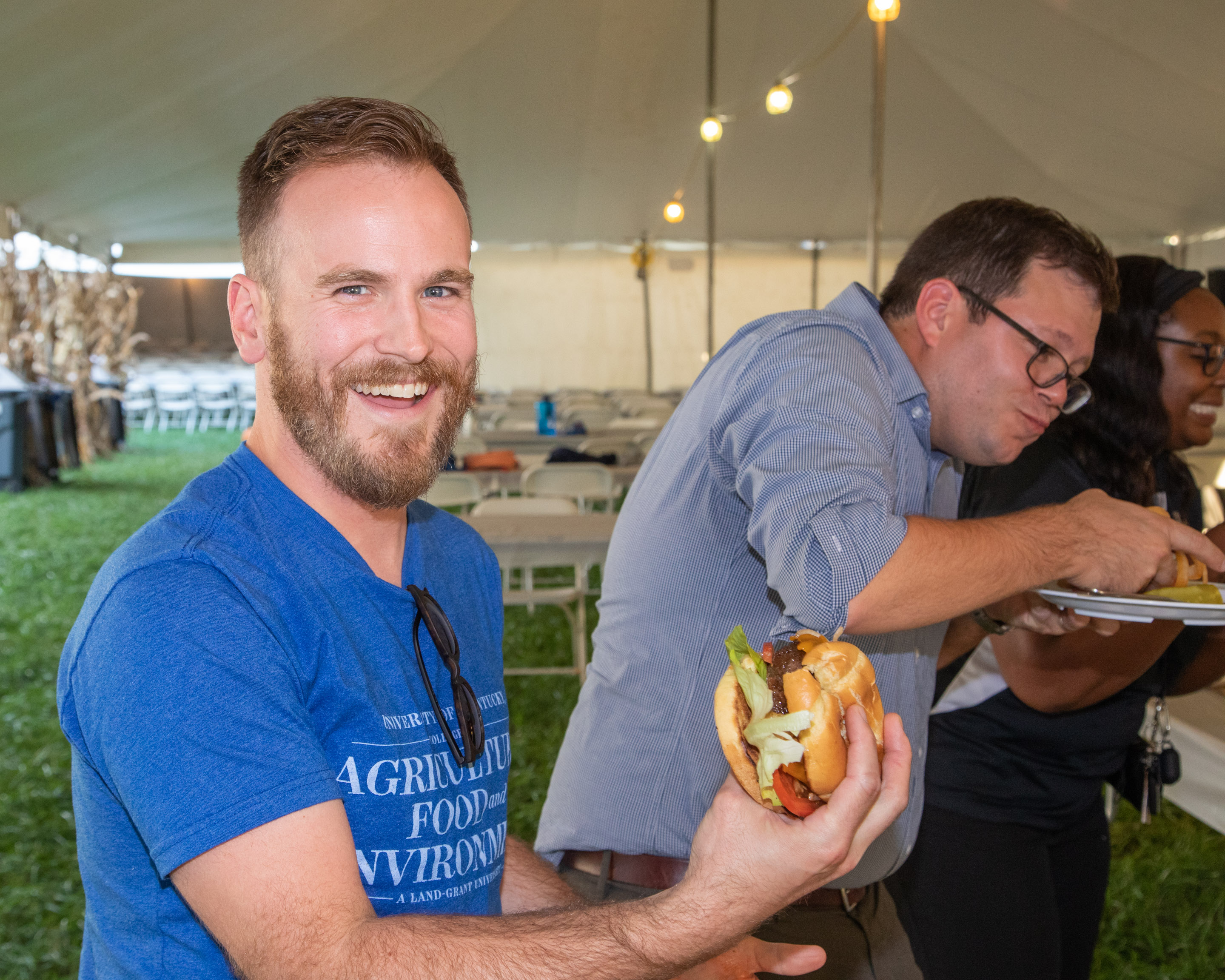 People hold burgers at the burger competition